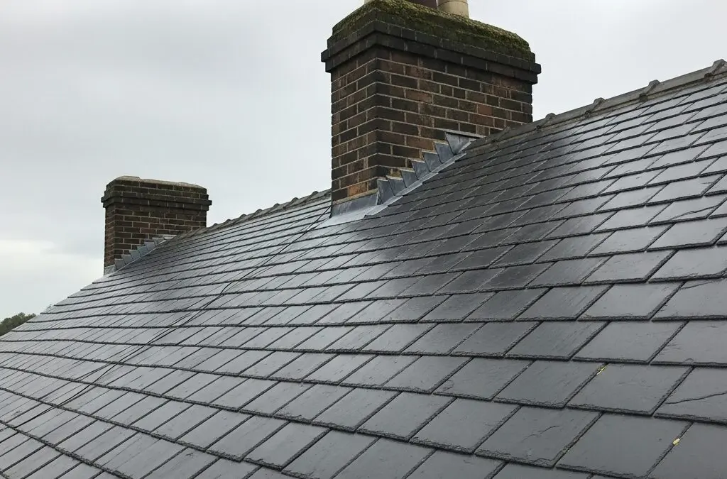 Natural slate roof on a Victorian terraced house in Sheffield with stone chimney stacks